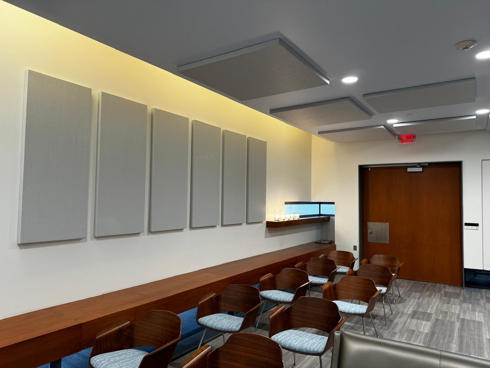 Grey acoustic wall panels and ceiling clouds in a meeting room