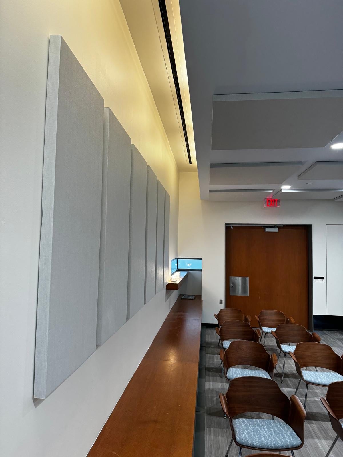 Tall grey acoustic wall panels lining a community meeting space