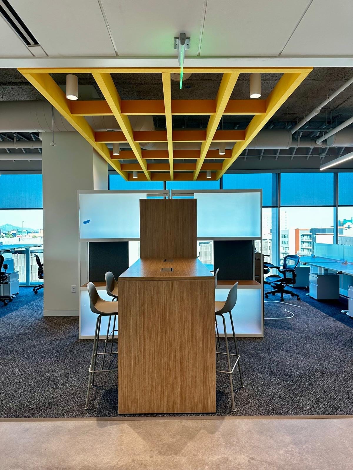 Yellow acoustic baffle grid suspended over a collaboration booth