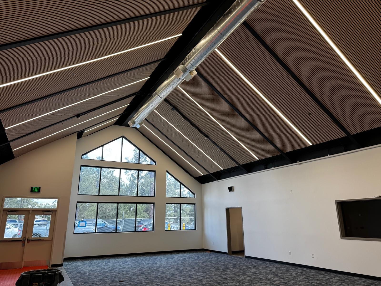 Acoustic treatment in a bright, beamed school commons
