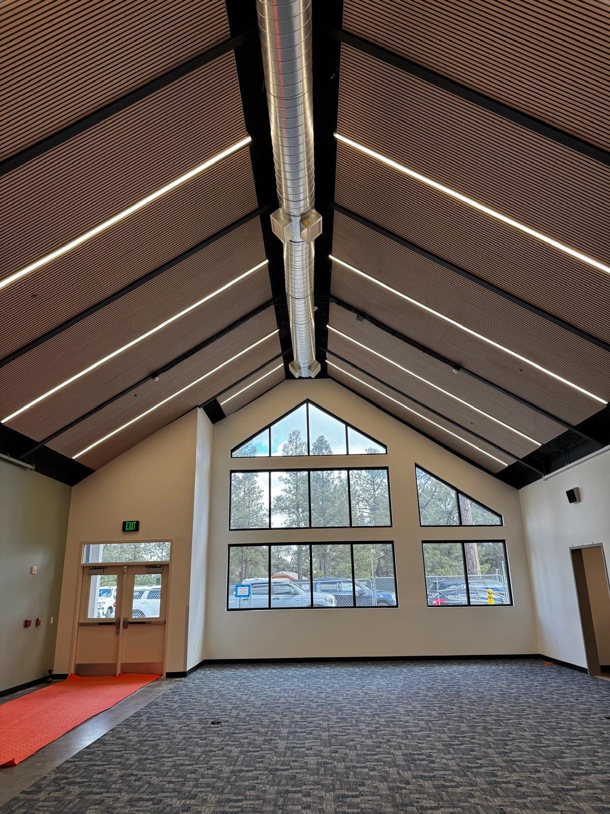 Wood-slat acoustic ceiling over a school commons entry