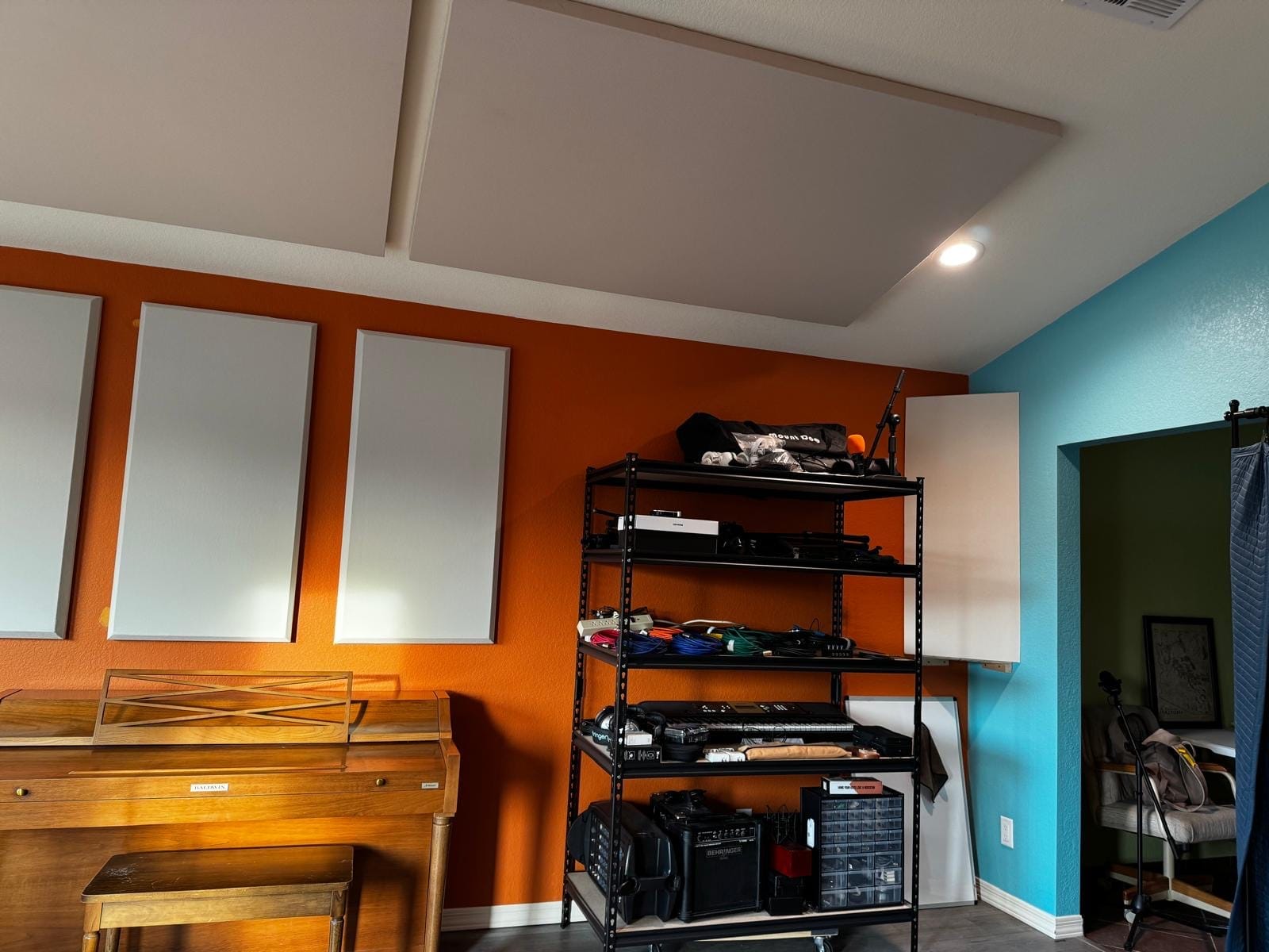 Acoustic panels on an orange music-room wall and ceiling cloud
